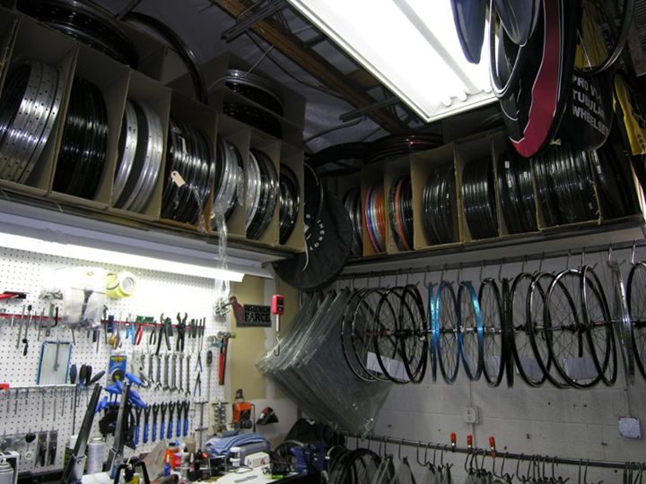 Rim storage shelves above the workbench with finished wheels hanging below