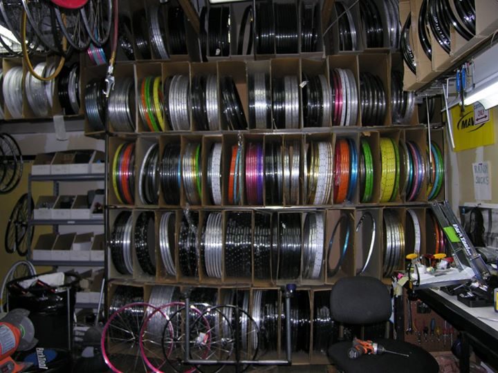 A floor-to-ceiling wall of rims in every color, ready to be built