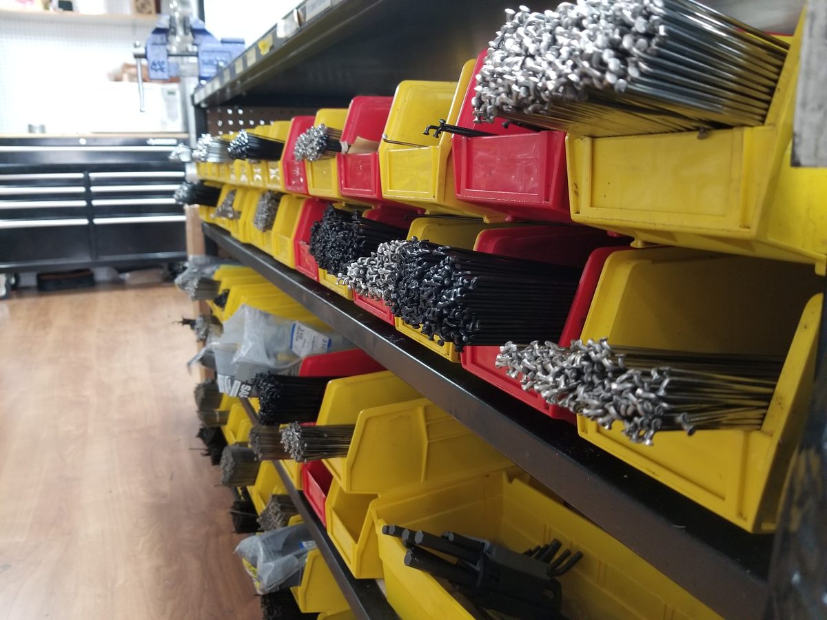 Rows of bins holding straight-gauge and butted spokes ready for cutting