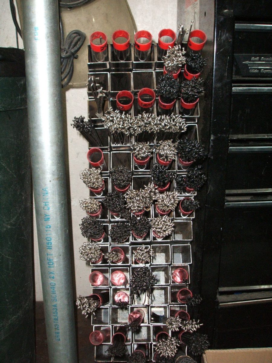The spoke rack, loaded with cut spokes and nipples sorted by length