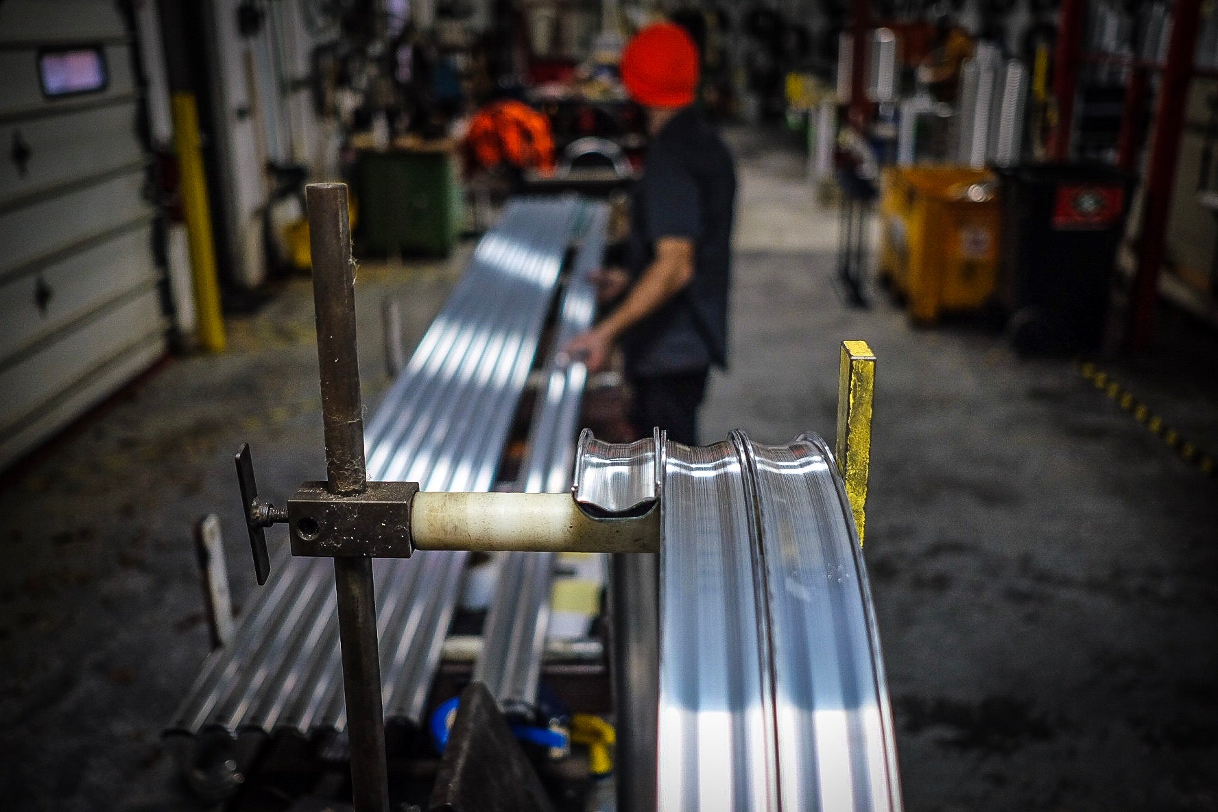 Rim extrusion being rolled into a hoop on Velocity's rolling machine (About Us page)